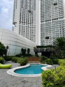 a swimming pool in front of two tall buildings at DFT Apartment "Rockwell View" Host By HomeStay in Manila