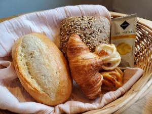 ein Korb mit Brot, Croissants und einem Bagel in der Unterkunft TRIP INN PostHotel Düren in Düren - Eifel + 72 Fotos