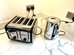 a toaster and slow cooker sitting on a counter at Kensington Olympia Apartment, Breakfast in London