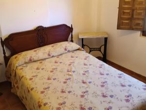 1 dormitorio con 1 cama con colcha de flores en El Balcón Del Jucar, en Alcalá del Júcar