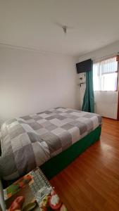 - une chambre avec un lit et une télévision dans l'établissement Hostal Jardín del Desierto, à Caldera