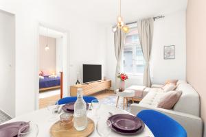 a living room with a table and blue chairs at Eclectic Apartment in Vršovice by Prague Days in Prague