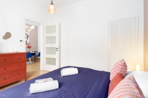 a bedroom with a blue bed with two towels on it at Eclectic Apartment in Vršovice by Prague Days in Prague