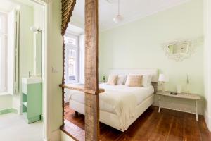 リスボンにある1898 Home & Suitesのベッドルーム(白いベッド1台、テーブル付)