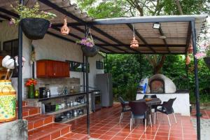 uma cozinha exterior com uma mesa e cadeiras sob uma pérgola em Cabañas VILLA PAOLA em Rivera