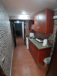 małą kuchnię z brązowymi szafkami i ceglaną ścianą w obiekcie Porto Elsokhna pyramids Family w mieście Ajn Suchna