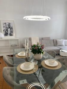 a living room with a glass table with chairs at Altbau-Oase der Eleganz: Stadtnaher Komfort pur in Wiesbaden