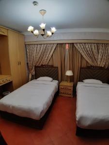 1 dormitorio con 2 camas y lámpara de araña en Porto Elsokhna pyramids Family en Ain Sokhna