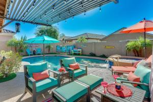 een patio met stoelen en tafels en een zwembad bij Mesa Oasis with Heated Pool, Hot Tub, and Grill! in Leisure World