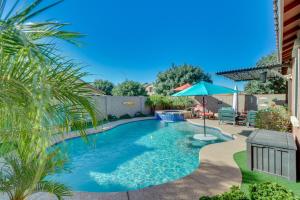 een zwembad met een parasol in de tuin bij Mesa Oasis with Heated Pool, Hot Tub, and Grill! in Leisure World