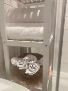 a shelf with towels and a basket of towels at Altbau-Oase der Eleganz: Stadtnaher Komfort pur in Wiesbaden