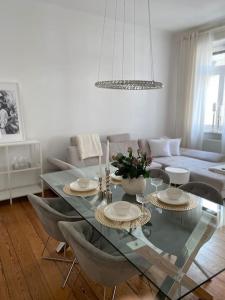 sala de estar con mesa de cristal y sillas en Altbau-Oase der Eleganz: Stadtnaher Komfort pur, en Wiesbaden