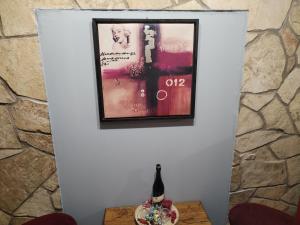 ein Bild an der Wand mit einer Flasche auf dem Tisch in der Unterkunft Skitnica Marilyn in Koprivnica