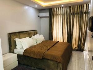 a bedroom with a large bed in front of a window at Autumn Green's 1,2 and 3 beds 1004 Estate in Lagos