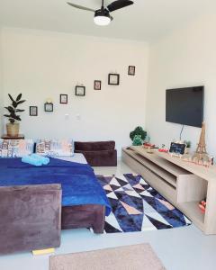 a living room with two beds and a flat screen tv at Império D in Tanabi