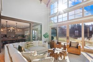 a living room with white furniture and a large window at Sweetgrass Getaway in Blowing Rock