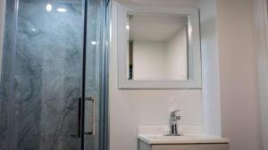 a bathroom with a shower and a sink and a mirror at Riaz's Peaceful Mississauga Home in Mississauga