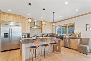 a kitchen with a large island with three bar stools at Sweetgrass Getaway in Blowing Rock +27 photos