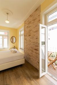 una habitación con una cama y una pared de ladrillo en 1898 Home & Suites, en Lisboa