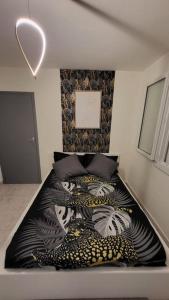 a bedroom with a bed with a black and white blanket at Appartement chaleureux, proche de la gare in Perpignan