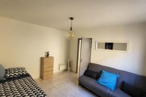a bedroom with a bed and a blue couch at Appartement chaleureux, proche de la gare in Perpignan