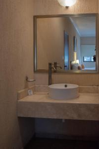 ein Bad mit einem Waschbecken, einem Spiegel und einem Waschbecken in der Unterkunft Tecnohotel Beach in San Benito