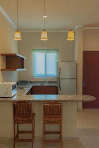 cocina con encimera con 2 sillas y nevera en Tecnohotel Beach, en San Benito