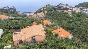 ein Dorf auf einem Hügel mit orangefarbenen Dächern in der Unterkunft Sara House in Ponta do Sol