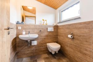 een badkamer met een wastafel, een toilet en een spiegel bij Der Bradler in Ebhausen