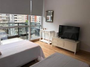 a living room with a flat screen tv on a dresser at Madero City Buenos Aires in Buenos Aires
