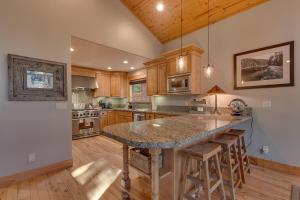 a kitchen with a large island with bar stools at Woodcrest at Tahoe Donner 3BR with Pool Table - 3000 sq ft in Truckee