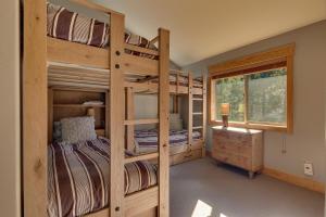 two bunk beds in a room with a window at Woodcrest at Tahoe Donner 3BR with Pool Table - 3000 sq ft in Truckee