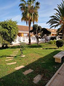 um parque com um banco e palmeiras em El paraíso del sol em Cartagena