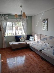 sala de estar con 2 camas y ventana en El paraíso del sol en Cartagena