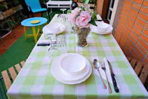 una mesa con platos y un jarrón de flores. en Apart 2 terrazas para 4 personas Bilbao centro, en Bilbao