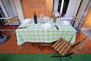 una mesa con un mantel a cuadros verde y blanco en Apart 2 terrazas para 4 personas Bilbao centro, en Bilbao