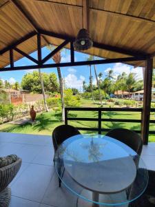 una mesa de cristal y sillas en un patio en Chalé em Maragogi, en Maragogi