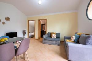 a living room with a couch and a table and chairs at Sara House in Ponta do Sol