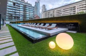 a row of lounge chairs and a pool in a building at Madero City Buenos Aires in Buenos Aires