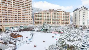 un cortile coperto di neve in una città con edifici di Sono Pet Clubs & Resorts Vivaldi Park a Hongcheon