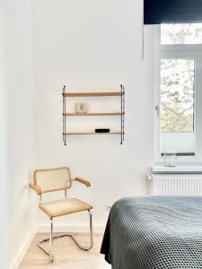 - une chambre avec une chaise à côté d'un lit dans l'établissement MAKERS + ROOMS APARTMENTS, à Detmold