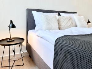 a bed with white sheets and a table with a lamp at MAKERS and ROOMS APARTMENT 01 Pauline 110qm Parkplatz 1-4 Personen in Detmold +41 photos