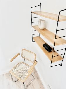 a chair in front of a wall with shelves at MAKERS and ROOMS APARTMENT 01 Pauline 110qm Parkplatz 1-4 Personen in Detmold