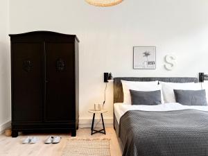 a bedroom with a black cabinet and a bed at MAKERS and ROOMS APARTMENT 01 Pauline 110qm Parkplatz 1-4 Personen in Detmold