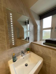 a bathroom with a sink and a mirror at Spacious Apartment NEC BHX in Solihull