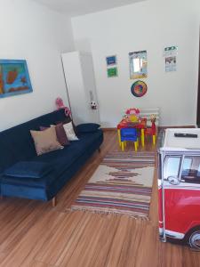 ein Wohnzimmer mit einem blauen Sofa und einem Tisch in der Unterkunft Aconchego do Bem-te-vi 2 qtos 60m2 Praia Grande in Arraial do Cabo