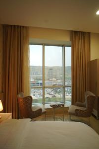 a hotel room with a bed and a large window at Sargali Duhok Hotel in Duhok