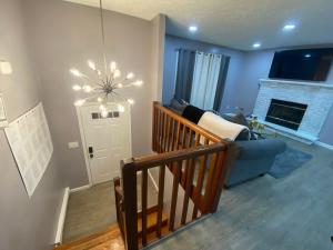 a living room with a staircase and a chandelier at The Tranquility in Tobyhanna