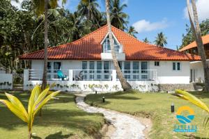 ein weißes Haus mit orangefarbenem Dach in der Unterkunft Beachfront Vacation Villa 