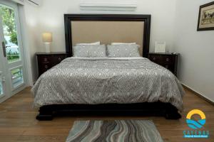 a bedroom with a large bed and two night stands at Beachfront Vacation Villa 